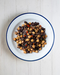 Sautéed chickpeas with black pudding and vegetables. Top view table with  decoration.