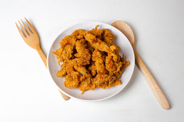 Crispy shrimp served on a plate with wooden spoon and fork decoration