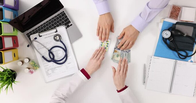 Doctor receives cash payment for prescription pills at clinic