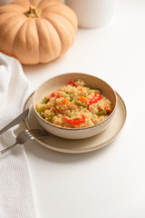 Quinoa vegetable salad on white wooden table. Vegetarian and diet food