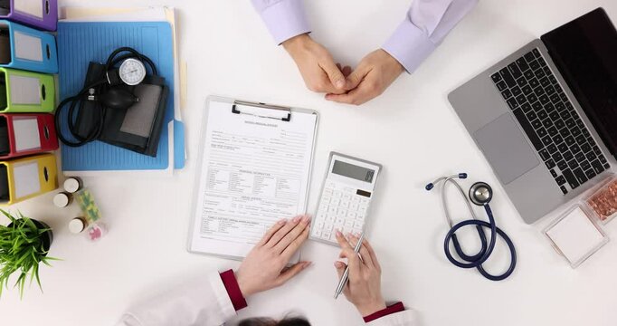 Doctor and patient review medical records and bills