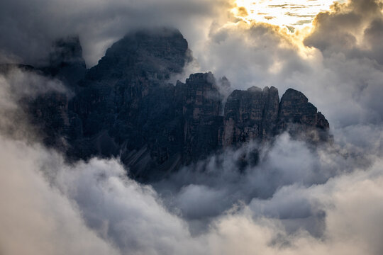 Dramatic cloudy morning in the Dolomites near Tre Cime di Lavaredo, with mist and rolling clouds over rugged mountain peaks.