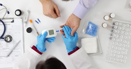 Doctor performs finger prick blood glucose test on patient
