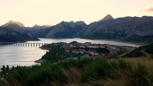 Desde un mirador, las vistas abarcan el pintoresco pueblo de Ria&ntilde;o, el embalse que lo rodea y las monta&ntilde;as imponentes. Un paisaje sereno y natural que refleja la belleza del entorno monta&ntilde;oso.