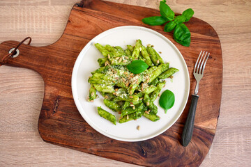 Pasta penne with fresh basil pesto, grated cheese and sunflower seeds
