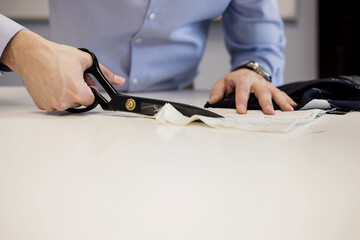 Close-up shot of tailor cutting textile using scissors