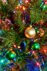 Close-Up of Decorated Christmas Tree with Red, Green, and Gold Ornaments, Pine Cones, and Colorful...