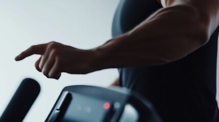 A close-up of a person's hand adjusting settings on a fitness machine.