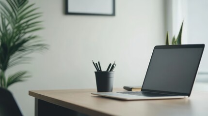 Fototapeta premium A minimalist workspace featuring a laptop, plant, and stationery for productivity.