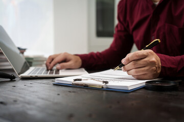 A male lawyer is working at his desk on an online judicial review, focusing on justice, fairness,...