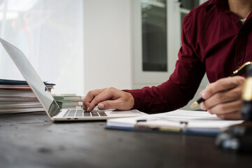 A male lawyer is working at his desk on an online judicial review, focusing on justice, fairness, and legal compliance.He reviews cases, contracts, and legal matters based on general law principles