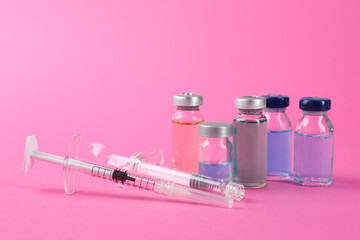 Pharmacist. Glass vial with medication and syringes on pink background