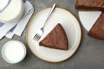 Piece of tasty chocolate sponge cake served on grey table, flat lay