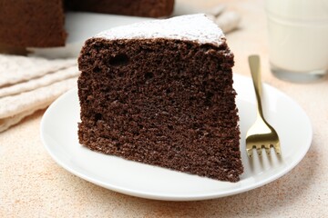 Piece of tasty chocolate sponge cake served on light table, closeup