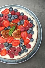 Delicious chocolate sponge cake with berries on grey table, top view