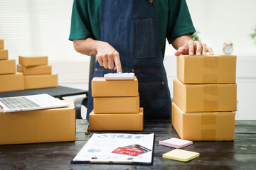 A man is working at his desk, preparing parcel boxes for shipment. He checks and packs items carefully, using shockproof materials, and attaches labels before sending them to customers via EMS.