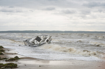 Denmark, Jutland, Fredericia, October 1, 2024. Storm on the coast with a sailboat that has torn itself from its moorings and is stranded on the beach.