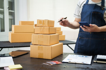 A man is working at his desk, preparing parcel boxes for shipment. He checks and packs items carefully, using shockproof materials, and attaches labels before sending them to customers via EMS.