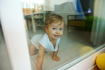 Adorable baby crawling indoors with a curious smile