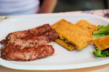piatto a base di salsicce e fette di polenta