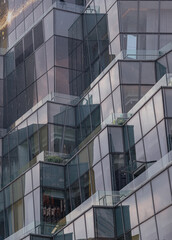 Architecture exterior of Modern building with many glass wall reflecting with the sky background at afternoon. Copy space, Selective focus.