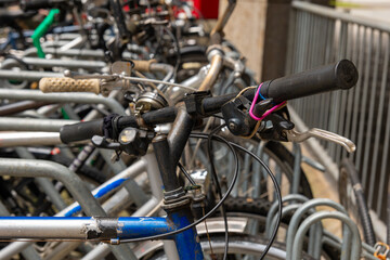 Obraz premium Old bicycle with worn handlebars parked in a row with other bikes