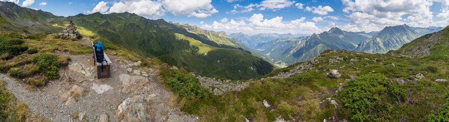 peaceful panoramic view over stony and rocky mountain with alpine meadows and gravel fields, recreational hikers path way through pasture and boulders up to the summit, holiday destination