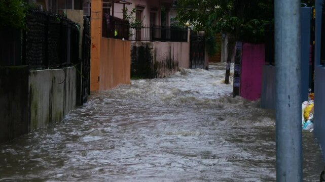 Alleyway and buildings flooded with heavy rainfall water, wide angle shot of flood water flowing in a alleyway between flooded buildings in Kathmandu, Nepal during September monsoon 2024.