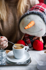 Woman drinking coffee in cafe and holding christmas decoration. 