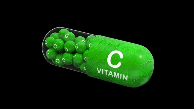 green pill or capsule filled with vitamin C. 3D animated model of granule vitamins complex. Isolated on the black background. Alpha channel. 3D rendering. Seamless loop