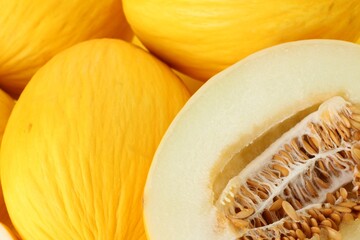 Whole and cut ripe melons as background, closeup