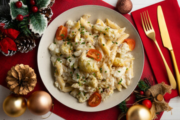 Macaroni and cheese with cauliflower. Top view table with Christmas decoration.