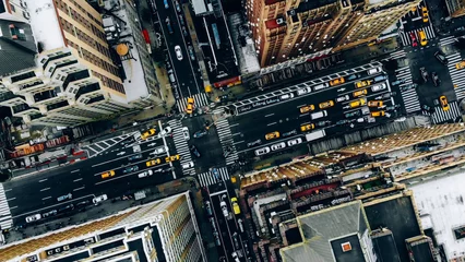 Fotobehang New York Aerial view of New York downtown building roofs. Bird's eye view from helicopter of cityscape metropolis infrastructure, traffic cars, yellow cabs moving on city streets and crossing district avenues  © BullRun
