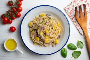 Spaghetti with pineapple, ham and cream sauce. Top view table with  decoration.