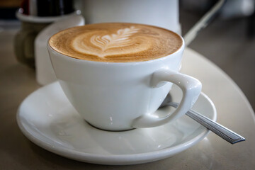 A close up of a latte with decorative pattern, with a shallow depth of field
