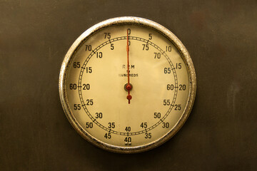 Dial on the wall. A tachometer mounted to a testing machine measures revolutions per minute of an...