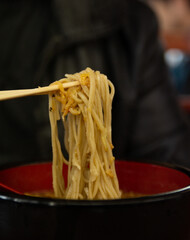 Ramen noodles picked up by chopticks.
