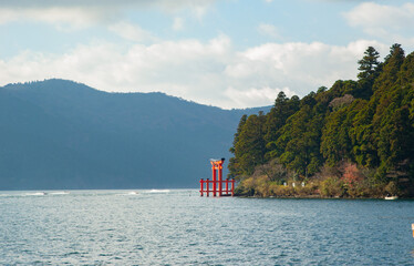 Red Japanese Torii gate by the Lake in Hakone, Japan.