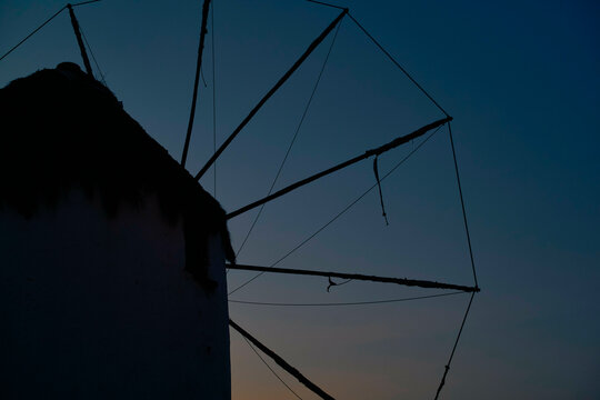 Silhouette of a traditional windmill against a twilight sky.