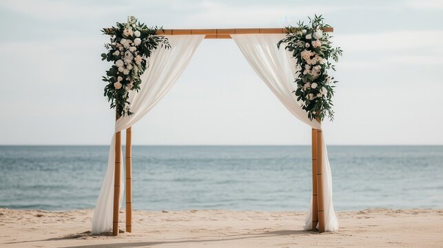 Rustic wedding altar adorned with flowers on a sandy beach by the ocean.