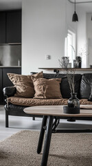 A cozy living room featuring stylish black sofa adorned with plush cushions, modern coffee table, and decorative vase. warm tones create welcoming atmosphere