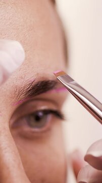 Beautician preparing girl for permanent eyebrow makeup, performing eyebrow tattooing