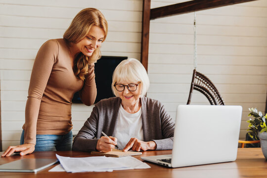 Beauty middle aged lady teaching her mom to use computer
