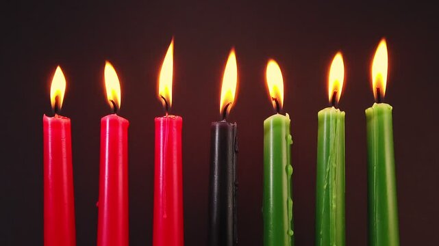Kwanzaa festival concept with seven candles red, black and green on black background, motion