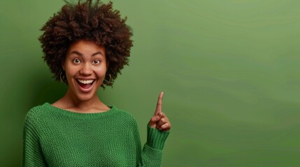 A woman with curly hair is pointing to the sky