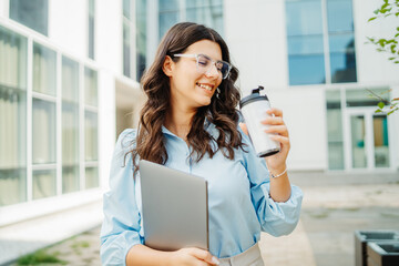 Fototapeta premium Young successful woman is going to work at modern business building 