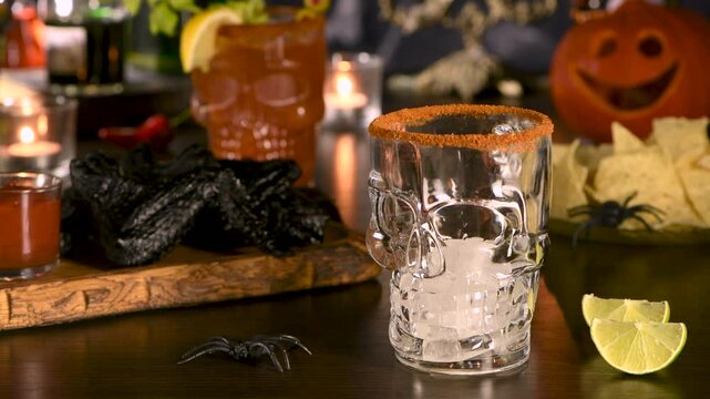 Michelada Cocktail, Bloody Mary. Mexican drink with tomato juice, lime juice, sauce and beer, garnished with celery stalk, lemon, olives. Halloween party ideas.  