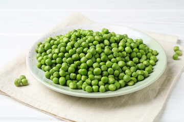 Fresh green peas on white wooden table