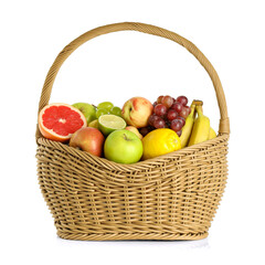 Many different fresh fruits in wicker basket isolated on white