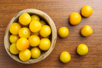Fresh plums on wooden table, flat lay